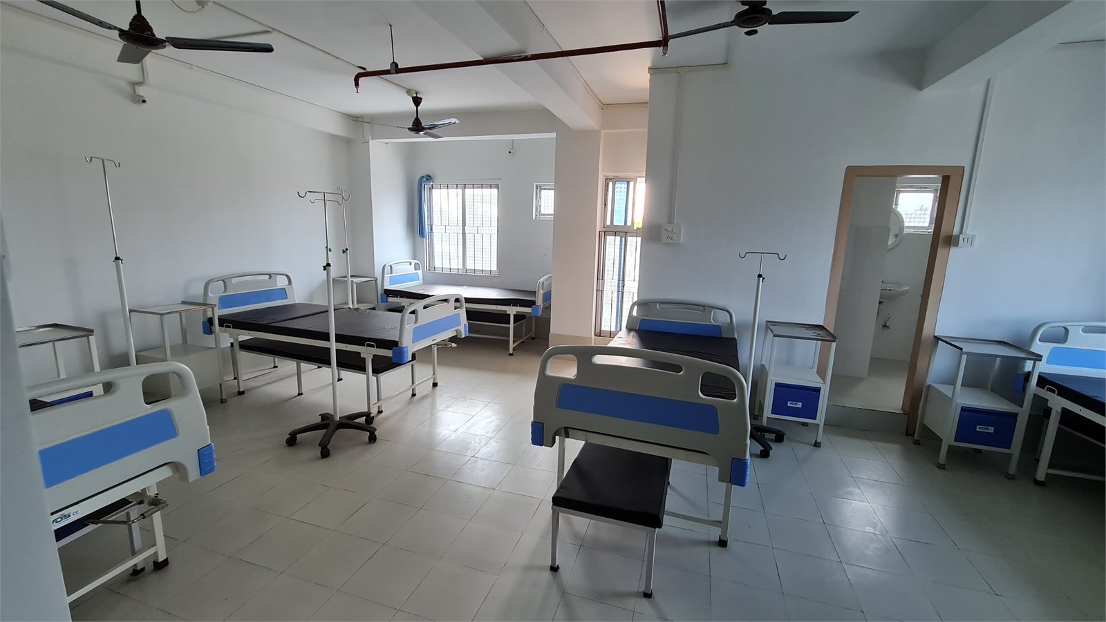 An empty inpatient ward with hospital beds